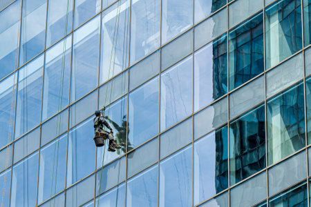 Industrial climber cleaning windows on the facade of an office building at a height.のeditorial素材