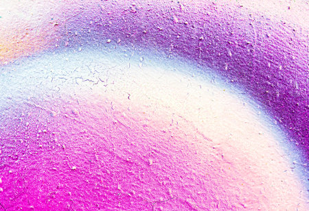 A fragment of colorful graffiti painted on a wall. Abstract urban background for design. spray...