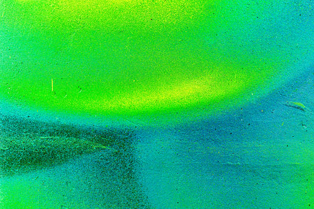 A fragment of colorful graffiti painted on a wall. Abstract urban background for design. spray...