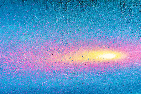 A fragment of colorful graffiti painted on a wall. Abstract urban background for design. spray...