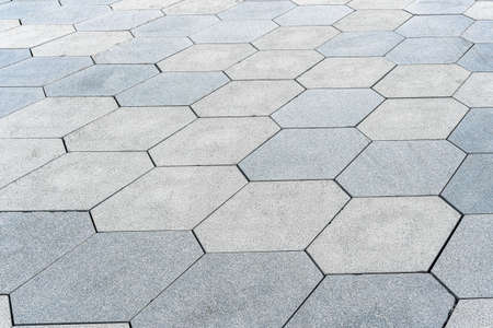 The texture of a monotonous hexagonal tiled pavement with perspective.