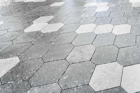 The texture of a monotonous hexagonal tiled pavement with perspective.