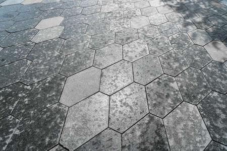 The texture of a monotonous hexagonal tiled pavement with perspective.