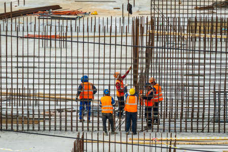 RUSSIA, KALUGA - AUGUST 15, 2022 : A group of workers assembling the framework of a building from...