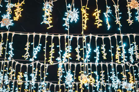 Christmas garlands with LED lamps against the black night sky. Xmas decorations.
