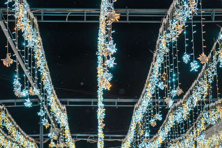Christmas garlands with LED lamps against the black night sky. Xmas decorations.