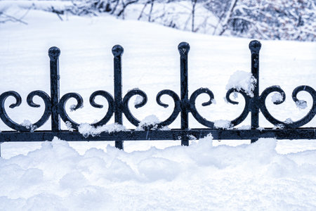 Black metal grate covered with snow in winter. Snowfall and winter weather concept.の写真素材
