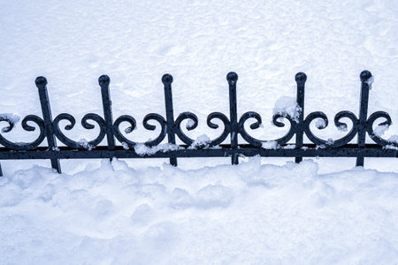 Black metal grate covered with snow in winter. Snowfall and winter weather concept.の写真素材
