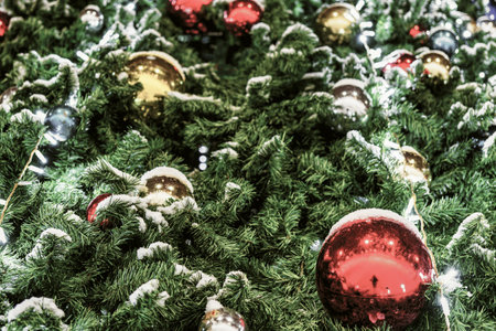 Christmas balls and glowing garlands on an artificial spruce. Xmas abstract background.の写真素材