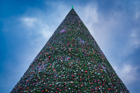 Artificial Christmas tree in garlands at twilight. Xmas decorations and lights.の写真素材