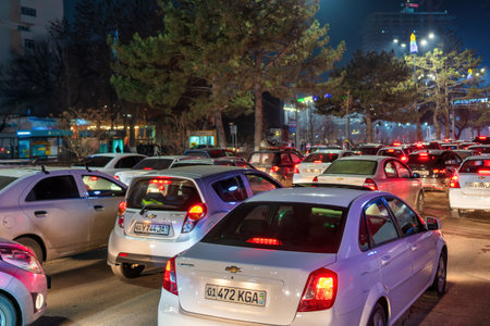 Uzbekistan, Tashkent - December 27, 2022: Car traffic lights at night city. Traffic jam in evening...