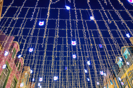 Uzbekistan, Tashkent - DECEMBER 20, 2022: Festive hanging LED garlands against the background of the night sky. Holiday decorations.のeditorial素材