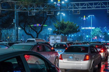 Uzbekistan, Tashkent - December 27, 2022: Car traffic lights at night city. Traffic jam in evening...