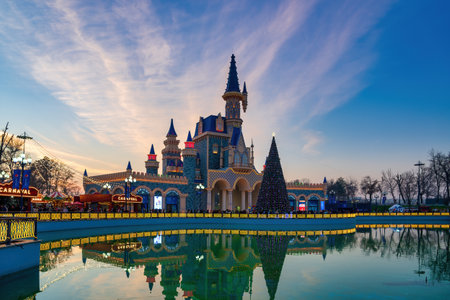 TASHKENT, UZBEKISTAN - DECEMBER 20, 2022: "Magic City" amusement park on a late evening reflected in a water.のeditorial素材