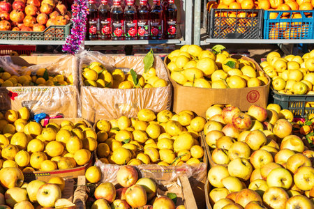 A fruit stand on a bazaar counter illuminated by the sun. Oranges, pineapples, lemons and apples.の写真素材