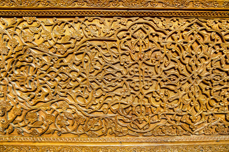 Fragment of an ancient carved wooden door. Ornate background.