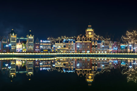 TASHKENT, UZBEKISTAN - DECEMBER 20, 2022: "Magic City" amusement park on a late evening reflected in a water.のeditorial素材