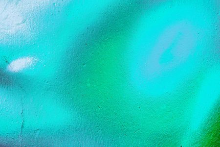 A fragment of colorful graffiti painted on a wall. Abstract urban background for design. spray...