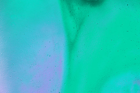 A fragment of colorful graffiti painted on a wall. Abstract urban background for design. spray...