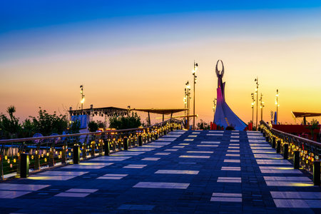 UZBEKISTAN, TASHKENT - APRIL 25, 2023: The territory of the park New Uzbekistan with Monument of Independence in the form of a stele with a Humo bird at twilight in spring. view from a bridge.のeditorial素材