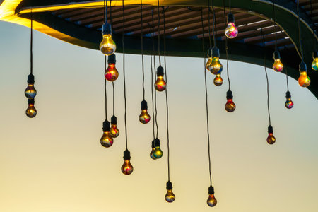 Festive hanging garlands with light bulbs against the background of a twilight sky. Holiday decorations.の写真素材