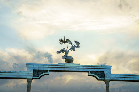 TASHKENT, UZBEKISTAN - MAY 25, 2023: Independence Memorial at Independence Square in Tashkent illuminated at sunset with cloudy sky.のeditorial素材