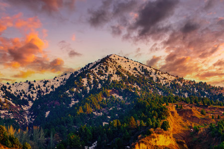 Mountain top covered with young snow and illuminated by the sun on a sunny spring day. mountain...