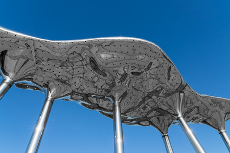 Street decorative decorations in the form of shiny steel abstract sculptures against a blue sky...