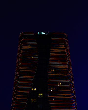 Uzbekistan, Tashkent - September 27, 2023: Hilton hotel building in night illumination on a blue sky background.のeditorial素材
