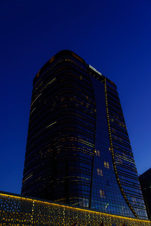 Uzbekistan, Tashkent - September 27, 2023: Hilton hotel building in night illumination on a blue sky background.のeditorial素材