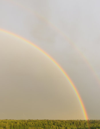 Rainbow against sunset sky. Natural abstract background. Weather after rain.の写真素材