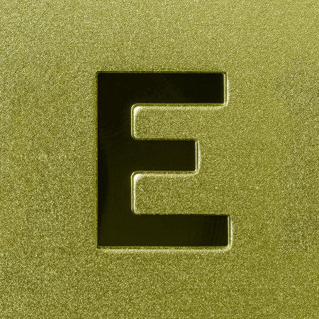 Letter E on a golden grained shiny metal surface. English alphabet. Element for design.の写真素材