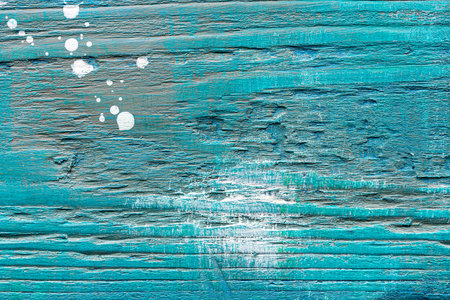 Blue painted textured wooden plank with colorful paint stains. Abstract background for design.の写真素材