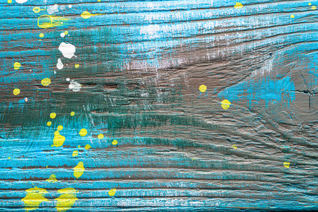 Blue painted textured wooden plank with colorful paint stains. Abstract background for design.の写真素材