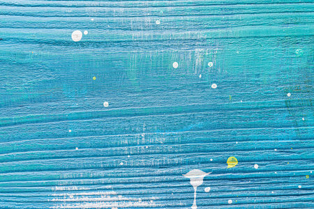 Blue painted textured wooden plank with colorful paint stains. Abstract background for design.の写真素材