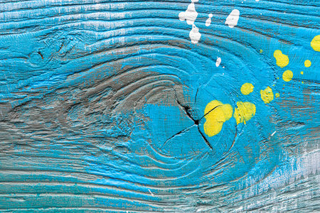 Blue painted textured wooden plank with colorful paint stains. Abstract background for design.の写真素材