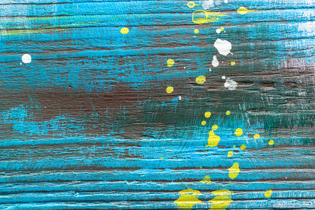 Blue painted textured wooden plank with colorful paint stains. Abstract background for design.の写真素材