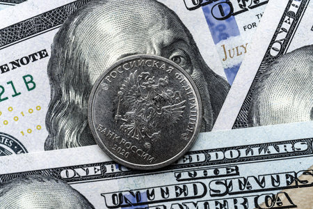 Close-up of a Russian rubles coin placed on US 100 dollar bills, on a white background. Concept of currency comparison and exchangeの写真素材