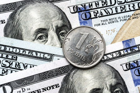 Close-up of a 1 Russian rubles coin placed on US 100 dollar bills, on a white background. Concept of currency comparison and exchangeの写真素材