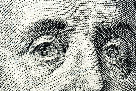 Close-up of intricate engraving of eyes found on a dollar bill, showing detailed linework and patterns, symbolizing currency designの写真素材
