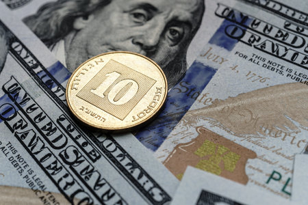 Close-up of a Israel shekel coin placed on US 100 dollar bills, on a white background. Concept of currency comparison and exchangeの写真素材
