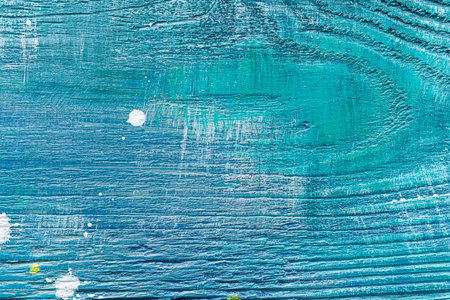 Blue painted textured wooden plank with colorful paint stains. Abstract background for design.の写真素材