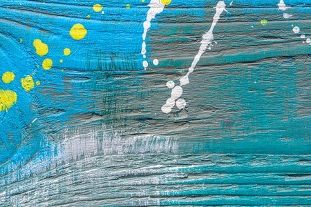 Blue painted textured wooden plank with colorful paint stains. Abstract background for design.の写真素材
