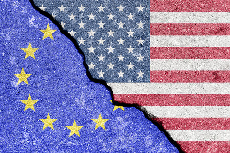 The crack between the flags of the United States and the European Union. The concept of problems in the relations of countries, trade tariffs and disagreements.の写真素材