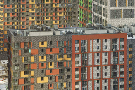 Urban residential complex with vibrant facades in a cityscape, sunny weather, and cloudy sky, concept of modern city architecture.の写真素材