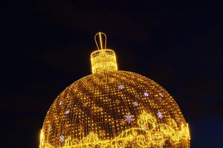 A luminous Christmas ball from garlands in a night park.の写真素材