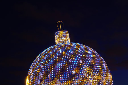 A luminous Christmas ball from garlands in a night park.の写真素材