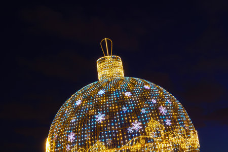 A luminous Christmas ball from garlands in a night park.の写真素材