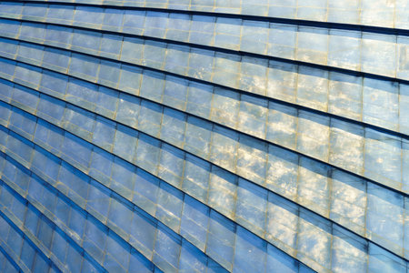 Close-up of blue metal roof panels with detailed texture and light reflections, forming a geometric pattern, architectural concept. Abstract background.の写真素材