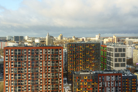 Urban residential complex with vibrant facades in a cityscape, sunny weather, and cloudy sky, concept of modern city architecture.の写真素材